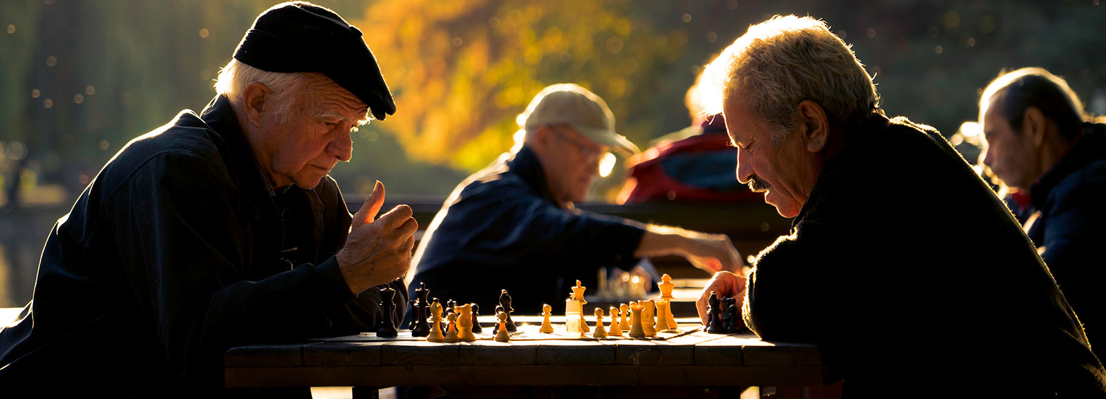 hommes âgés jouant aux échecs en plein air